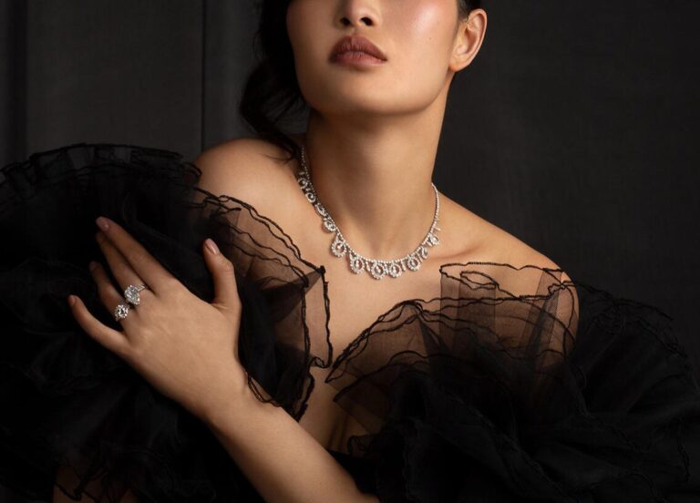 Model in black tulle wearing a diamond necklace and ring