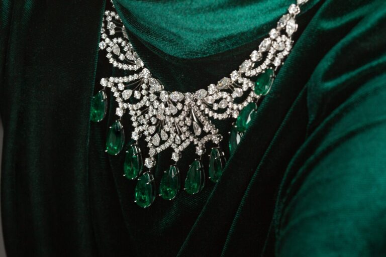 Diamond and emerald drop necklace photographed on green velvet
