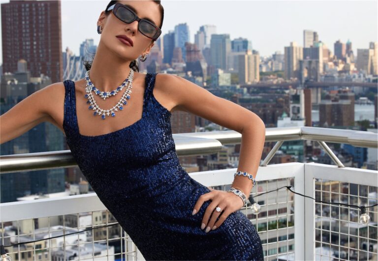 Model on a New York rooftop wearing a sapphire necklace, earrings, bracelet and ring
