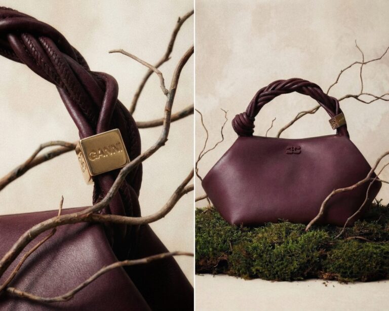 Burgundy leather handbag with a braided handle styled with bare branches and moss